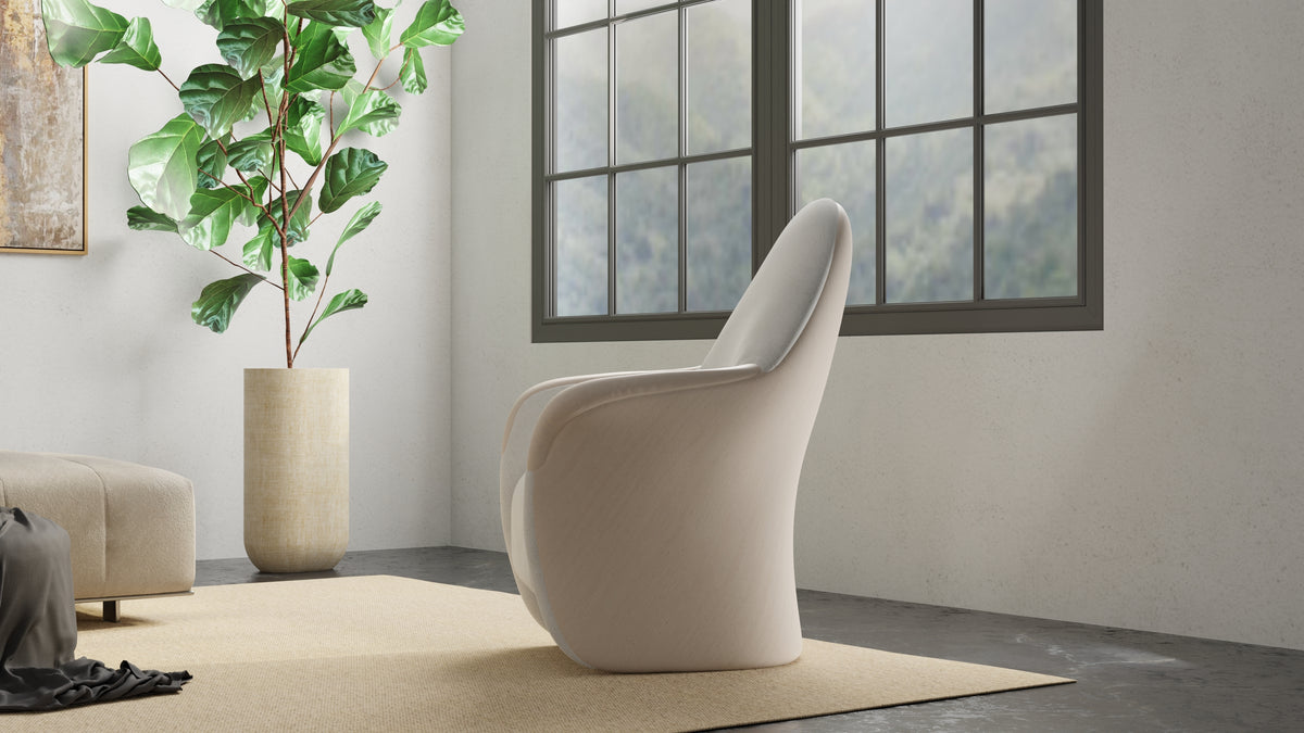 Rear and side view of the upholstered Attune chair beside a tall window and plant